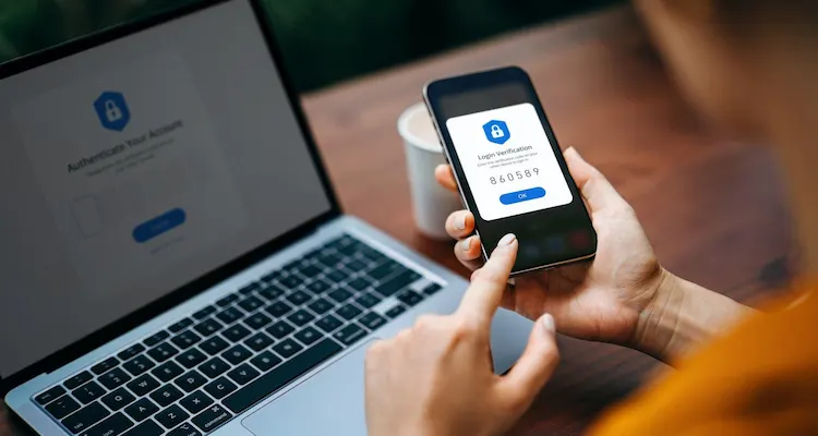 Person using two-factor authentication on a smartphone and laptop.